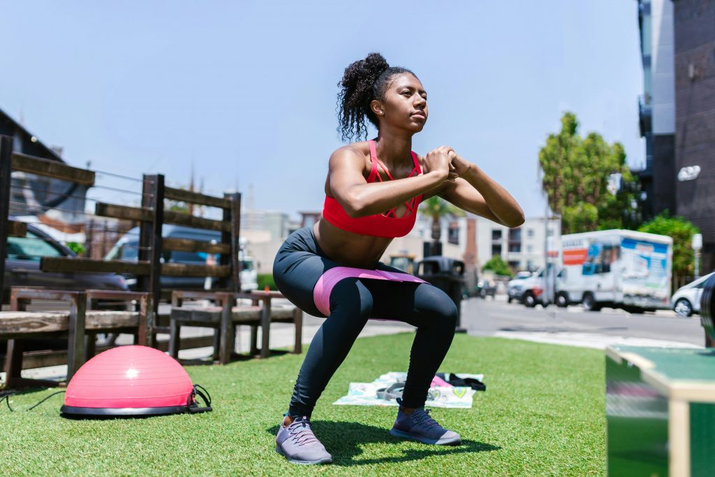 pexels-photo-8401956-8401956 African American woman exercising with a resistance band outdoors.